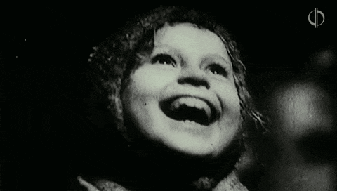 a black and white photo of a little girl laughing .