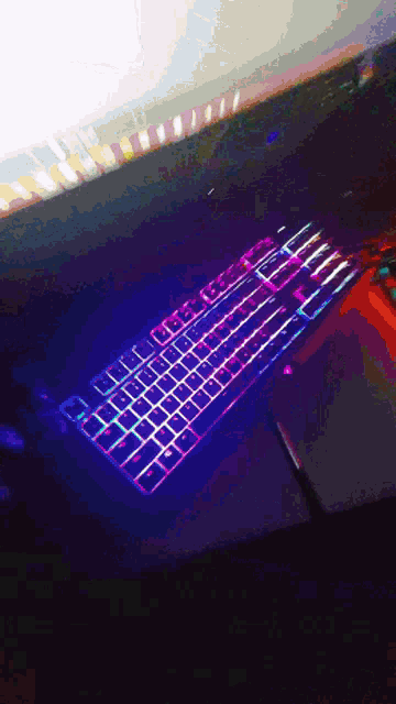 a keyboard is lit up in purple and blue lights