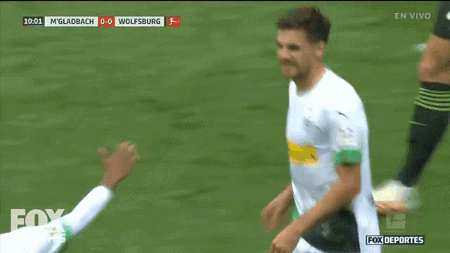 two soccer players are giving each other a high five during a fox deportes broadcast