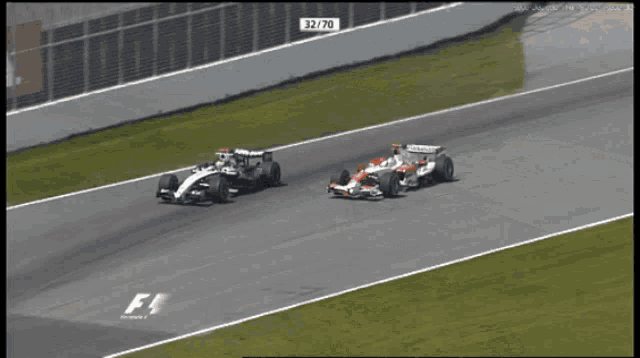 two racing cars are on a race track and one of them has the number 32/70 on it