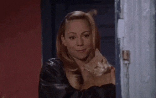 a woman is holding a cat in her arms and says hi