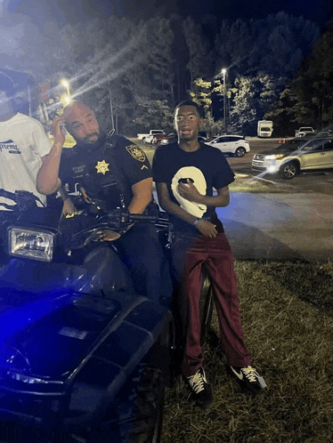 a police officer sits on a four wheeler with a man sitting on the back
