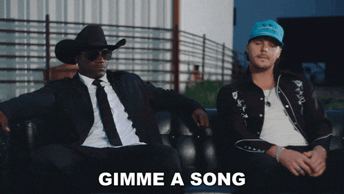 two men sitting on a couch with the words gimme a song written on the bottom