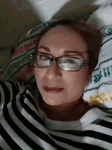 a woman wearing glasses and a black and white striped shirt