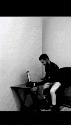 a man sitting at a desk with a laptop on it