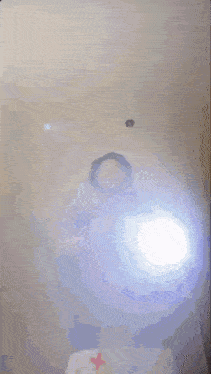a person is standing in a room with a light shining through a hole in the ceiling .
