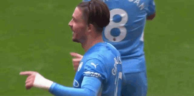 a soccer player wearing a blue jersey is holding his head .