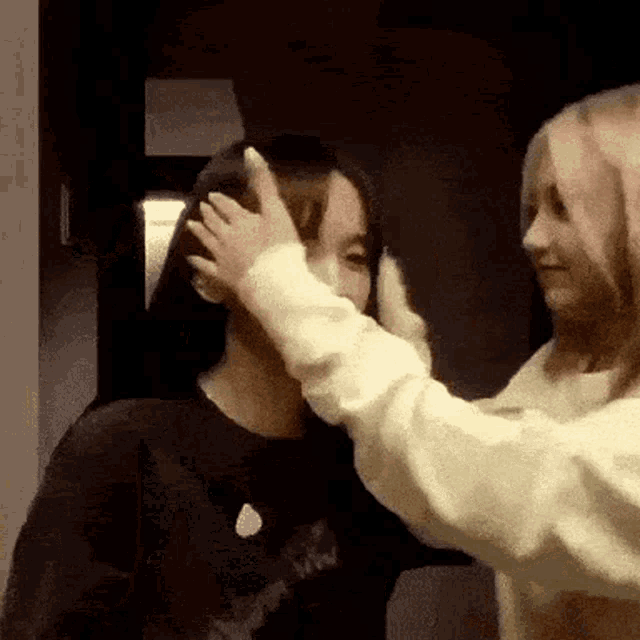 two women are touching each other 's faces .