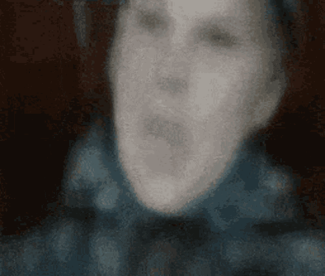 a blurry image of a person 's face with their mouth open