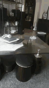 a glass table in a room with a bottle of pills on it