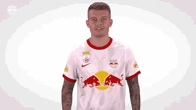 a man in a red bull jersey is raising his arms in the air