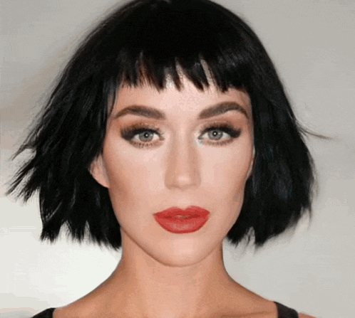 a woman with short black hair and red lipstick
