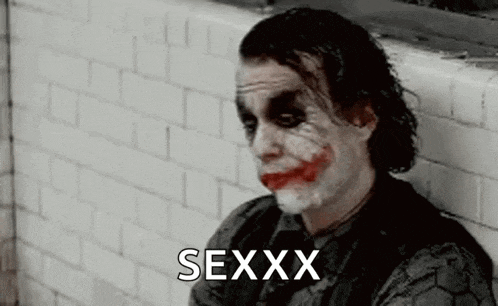 the joker is leaning against a brick wall and making a funny face with his mouth open .