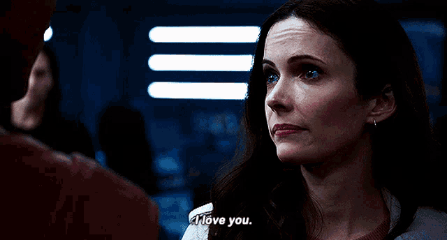 a woman says i love you to a man in a dark room