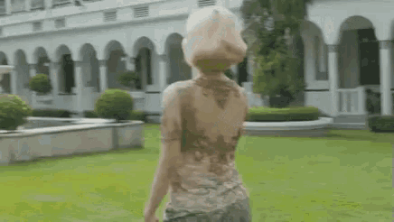 a woman standing in front of a fountain with the words " sini mas " on the bottom