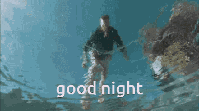 a man is swimming in the ocean with the words good night written above him