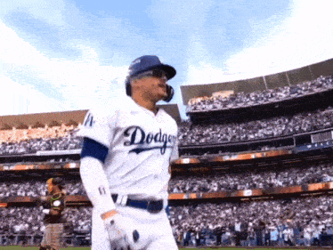 a man in a dodgers uniform stands in front of a stadium full of people