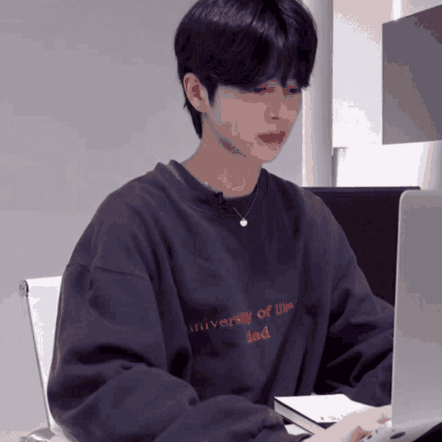 a young man wearing a sweatshirt that says university of illinois dad