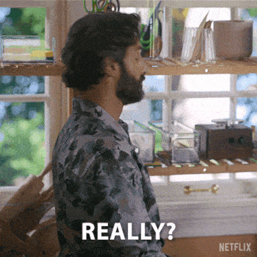 a man with a beard says really in front of a shelf