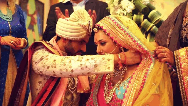 a bride and groom are getting married and the bride is wearing a yellow veil