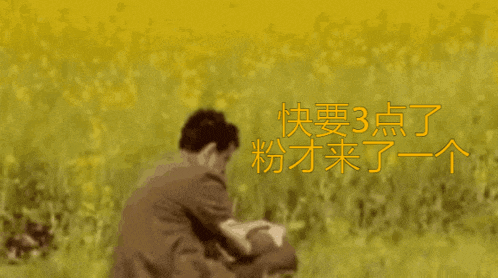 a man in a suit and tie stands in a field with chinese writing