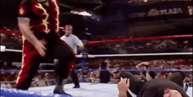 a wrestling match is taking place in a stadium with a plaza sign in the background