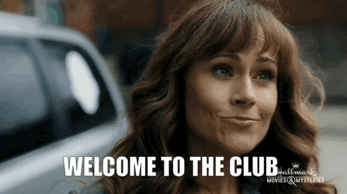 a woman is smiling with the words welcome to the club behind her