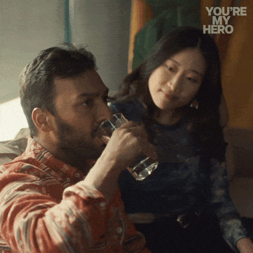 a man drinking from a glass next to a woman with the words " you 're my hero " written on the bottom