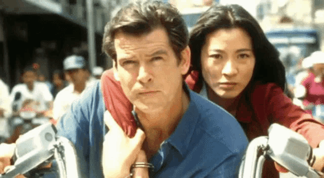 a man and a woman are riding a motorcycle and the man is wearing handcuffs
