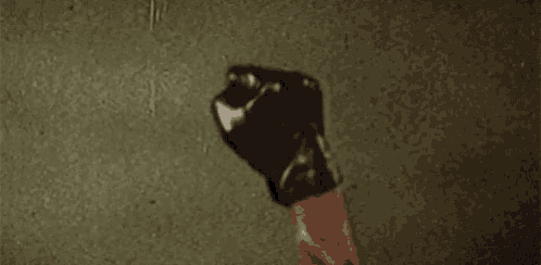 a close up of a person 's fist with a black glove on
