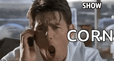 a man is yawning while talking on a cell phone with the words `` show corn '' written above him .