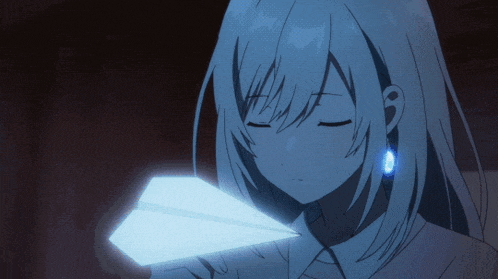 a girl is holding a paper airplane in her hand
