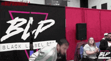 a man is kneeling down in front of a sign that says blp .