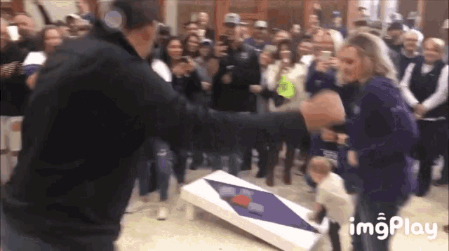 a group of people are playing a game of cornhole with a watermark that says imgplay on the bottom