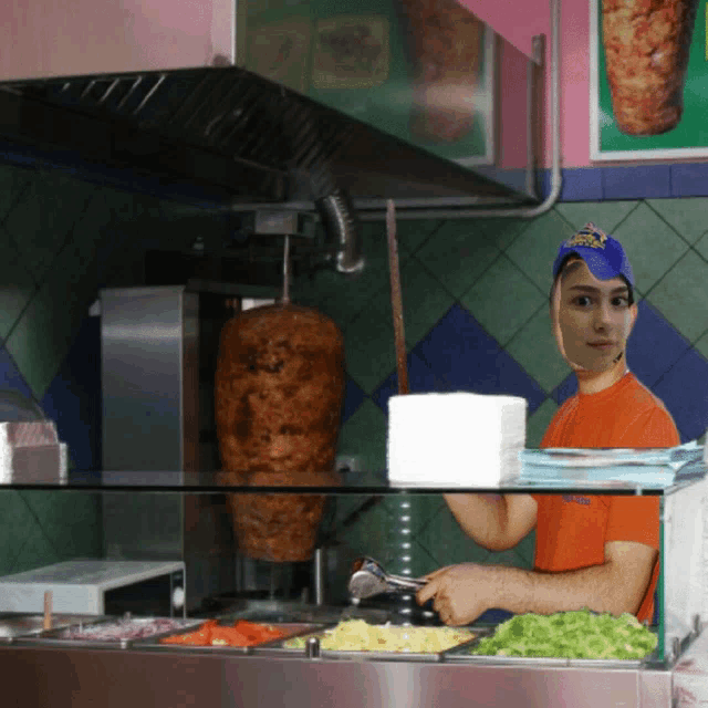 a man wearing a blue hat with the word king on it prepares food