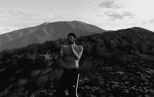 a man without a shirt is standing in a field