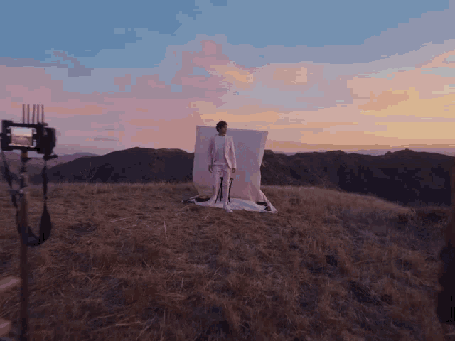 a man in a pink suit is standing in a field