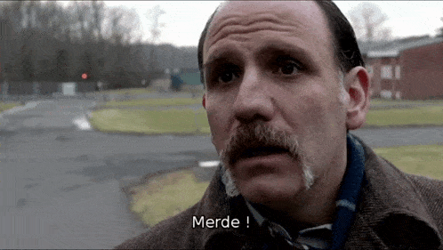 a man with a mustache has the word merde written on his face