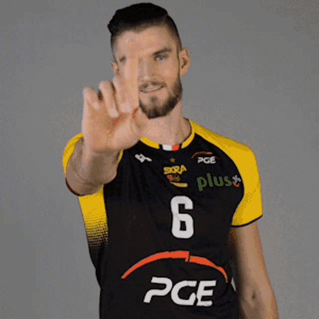 a man wearing a black and yellow pge plus shirt