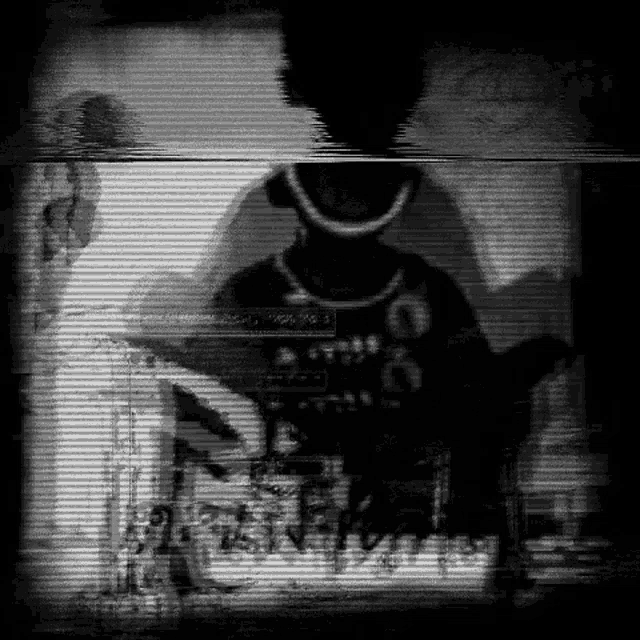 a black and white image of a person standing in a dark room with a blurred background .