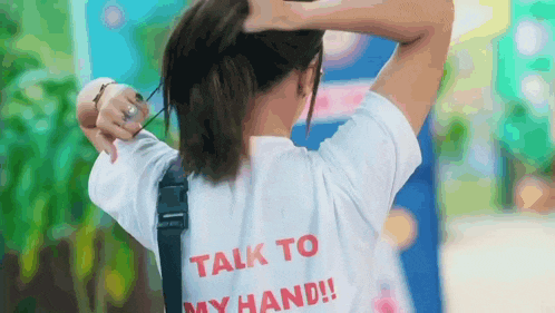 a woman wearing a white shirt that says talk to my hand on the back