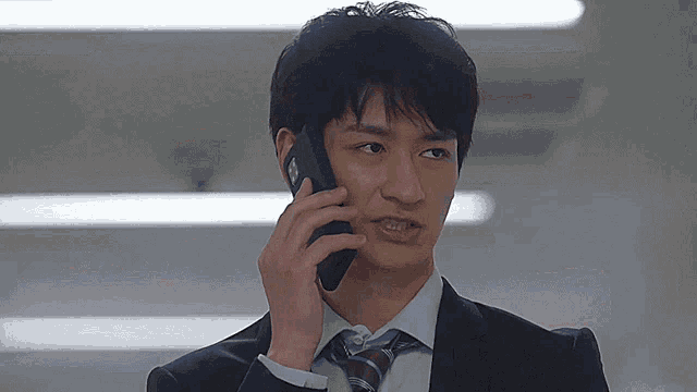 a man in a suit and tie is talking on a cellphone