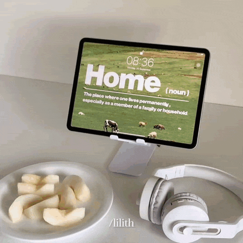 a tablet with the word home on the screen next to a plate of fruit