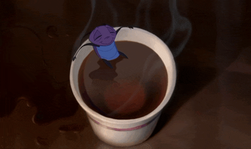 a cup of coffee with a cartoon character on top of it