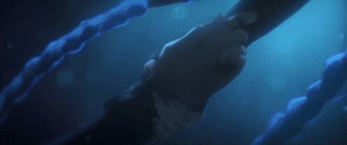 a person holding another person 's hand in a dark room