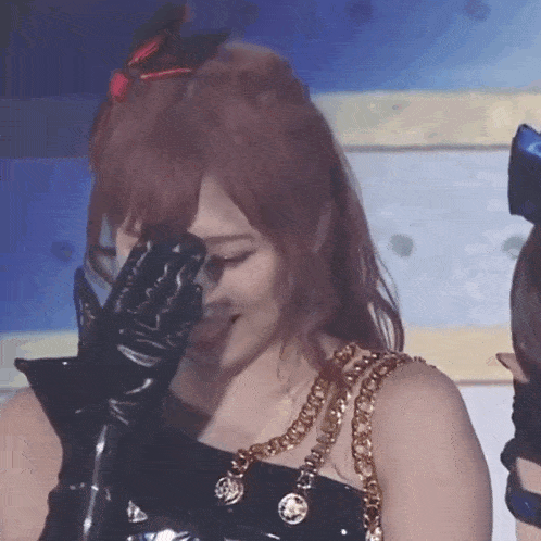 a woman wearing black gloves covering her face with her hand