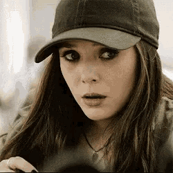 a close up of a woman wearing a hat and necklace