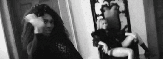 a woman is standing in front of a mirror in a room .
