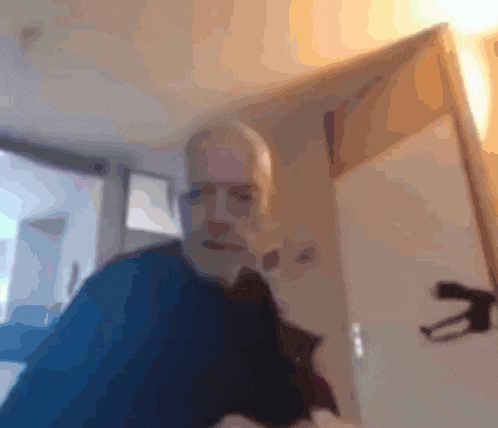 a blurry picture of a man taking a selfie in a room