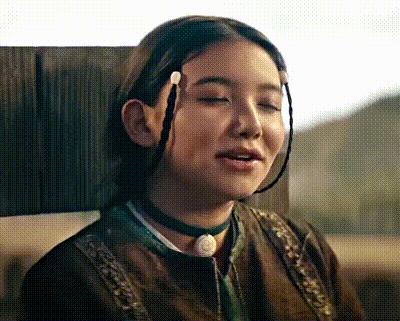 a close up of a woman with her eyes closed wearing a choker and braids .